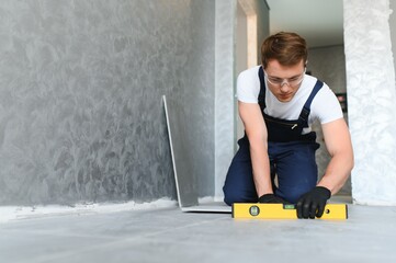 industrial worker, handyman installing big ceramic tiles