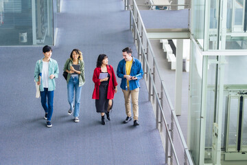 Multinational youth group walking in building. College students. High angle view.