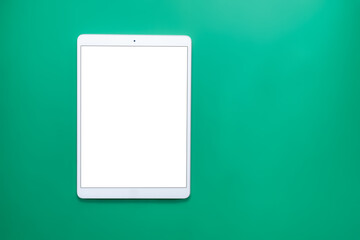 technology tablet, headphones, pencil on neutral green background with cardboard texture