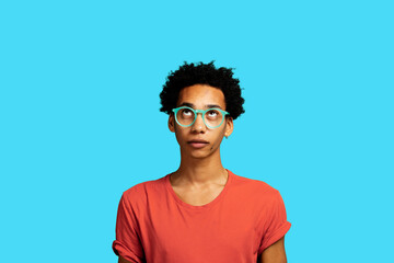 Portrait of African American man thinking looking up wearing eyeglasses and afro hair