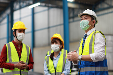 Group of technician engineer and businessman in protective uniform standing and discussing, researching, brainstorming and planning work together with protection mask at industry manufacturing factory