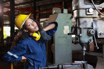 Technician engineer or worker woman in protective uniform maintenance operation or checking lathe...