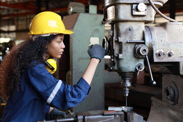 Technician engineer or worker woman in protective suit smiling and looking at camera maintenance operation or checking lathe metal machine at heavy industry manufacturing factory. Metalworking concept