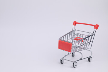 Close up red supermarket cart on white background. Online shopping, e-commerce, spending money concept. Shopping service on The online web. offers home delivery. free space for advertising