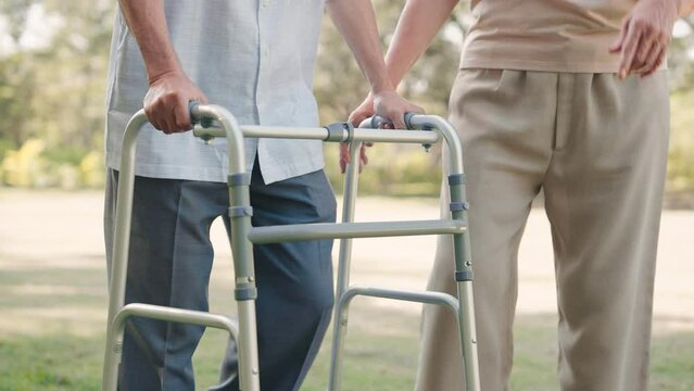 Asian senior woman help husband walking with walker cane in the public park, Take care concept