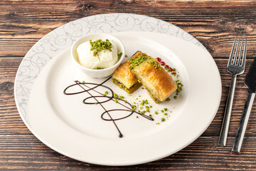 Traditional Turkish dessert pistachio baklava on a white porcelain plate