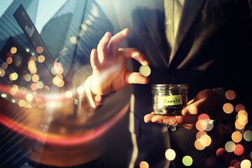 Businessman hand putting money (coin) in the glass jar, vintage tone effect. double exposure...