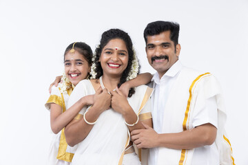 Obraz premium Smiling south indian parents and daughter posing in traditional clothing.