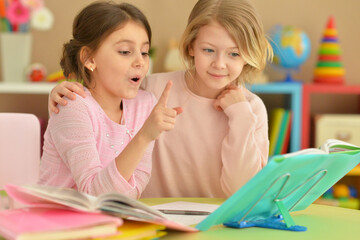 Obraz na płótnie Canvas Two beautiful little girls doping homework