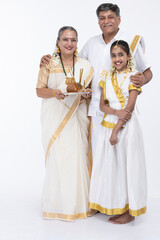 South Indian family posing in traditional clothing.