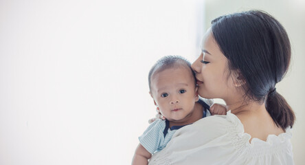 Close up portrait of beautiful young asian or caucasian mother day kissing her newborn baby in hospital. Healthcare and medical love asia woman lifestyle mother's day concept with copy space.
