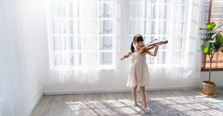 Portrait of young asian toddler little girl practice learning violin class room in white room at home or school isolated. Education, hobby leisure professional skill lifestyle concept © paulaphoto
