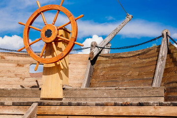 Old wooden ship. Close-up of the helm, boom and stern against a clear sky. Concepts: calmness,...