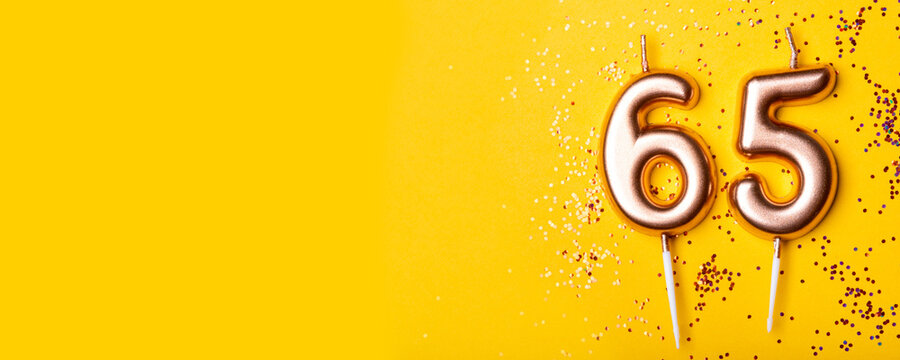 65 years celebration. Greeting banner. Gold candles in the form of number forty on yellow background with confetti.