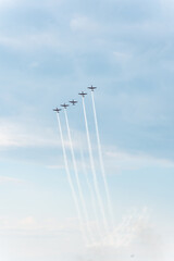 A group of aerobatic planes flies high in the sky