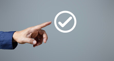 Male hand pointing circle with white check mark, check mark, tick icon, check mark, white circle check mark button done on gray background. Banner. Copy space. text area