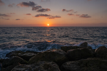 sunset on the seashore with a sandy steep shore.