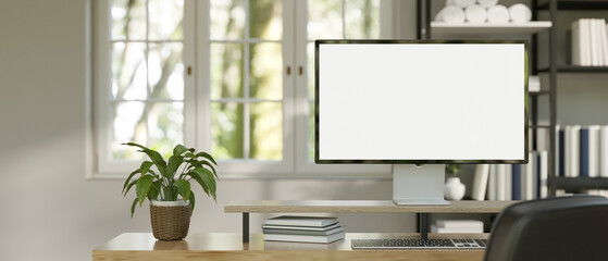 A modern PC computer blank screen mockup is on a table in a modern minimal home office.