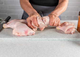 Cutting or carving raw chicken leg into shank and drumstick. Part of a series
