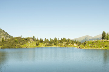 Fototapeta na wymiar MOUNTAIN LANDSCAPE WITH LAKE. MOUNTAINS IN THE BACKGROUND