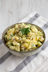 Homemade Potato Egg Salad with Pickles in a Bowl, side view.