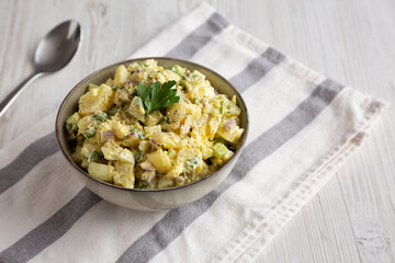Homemade Potato Egg Salad with Pickles in a Bowl, side view. Copy space.