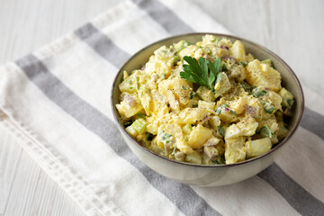 Homemade Potato Egg Salad with Pickles in a Bowl, side view. Space for text.