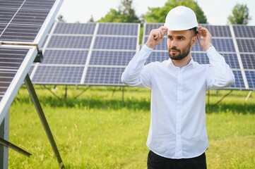 Naklejka premium Young architect standing by solar panels