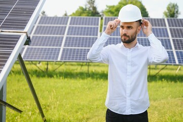 Young architect standing by solar panels