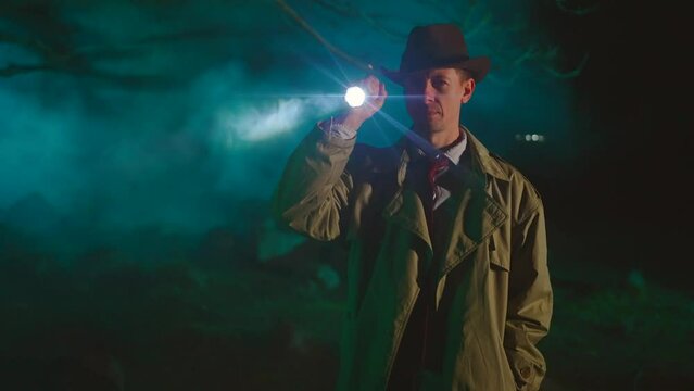 crime scene stylish portrait of a searching detective in a raincoat and hat with a flashlight looking for clues or retro style 1950