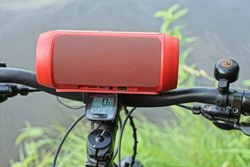 one plastic electric battery-powered musical small modern red color speaker mp 3 lies on a black...