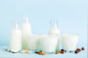 Set or collection of various vegan milk almond, coconut, cashew, on table background. Vegan plant based milk and ingredients, top view