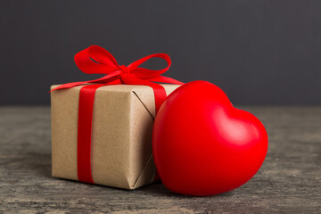 gift box with red bow and red heart on colored background. Perspective view. Flat lay