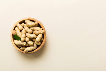 Fresh healthy peanuts in bowl on colored table background. Top view Healthy eating bertholletia concept. Super foods