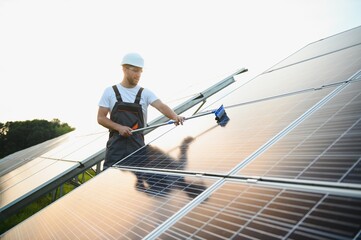 Worker cleaning solar panels after installation outdoors.