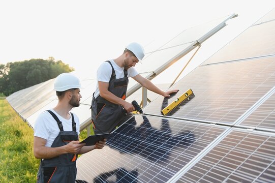 Worker team with solar panel. Worker team has success install solar panel at solar farm field.