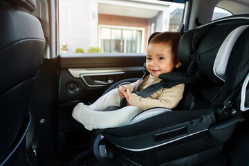 happy baby sitting in infant car seat, safety chair travelling