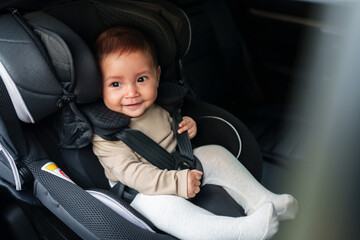 happy baby sitting in infant car seat, safety chair travelling