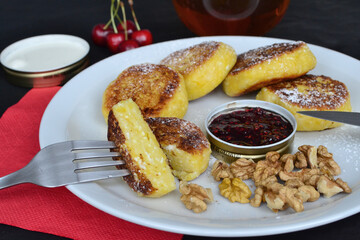 next to the cheese pancakes there is jam and sour cream in plates