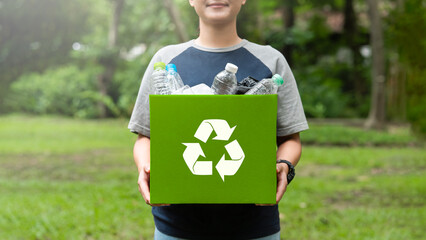 woman holding a garbage box recycling concept Recycle, recycle, plastic-free, junk food plastic packaging. on a forest nature green background