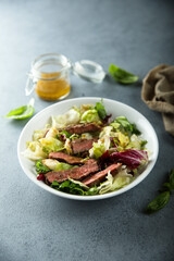 Green salad with beef steak and mustard dressing