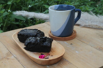 Brownies on a wooden plate and a cup of hot tea
