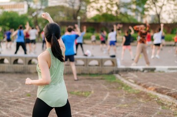 Female jogger. Fit young Asian woman with green sportswear aerobics dance exercise in park and enjoying a healthy outdoor. Fitness runner girl in public park. Wellness being concept