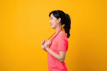 Fototapeta na wymiar Portrait young asian sports fitness woman happy wearing pink sportswear and stretching resistance band doing exercise training workout against yellow background. wellbeing healthy lifestyle concept.