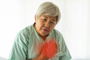 Senior asian adult elderly woman with chest pain suffering from heart attack, health and medical, heart health,  heart attack, world heart day, cardiovascular disease.insurance and hospital concept