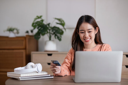 Image of young asian woman order online, shopping from home. Girl enter credit card info on webside to make purchase, using laptop to shop, paying bills with computer