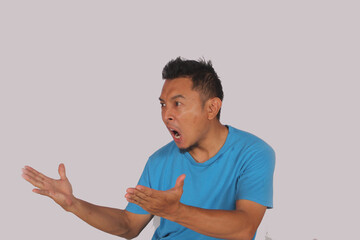 Surprised and worried asian man reacting to bad news, standing panicked over white background and...