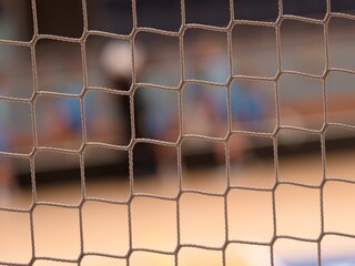 Tournament view through the protective net of a futsal match. - 617336204