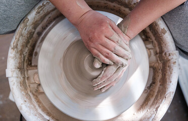 Top-down close up of a person working on pottery wheel. Pottery Concept. Ceramics. Artistic.