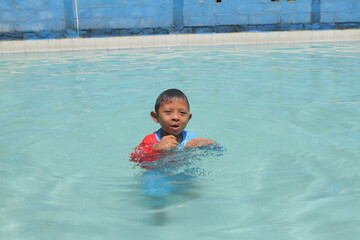 boys and girls practice swimming and playing in water
